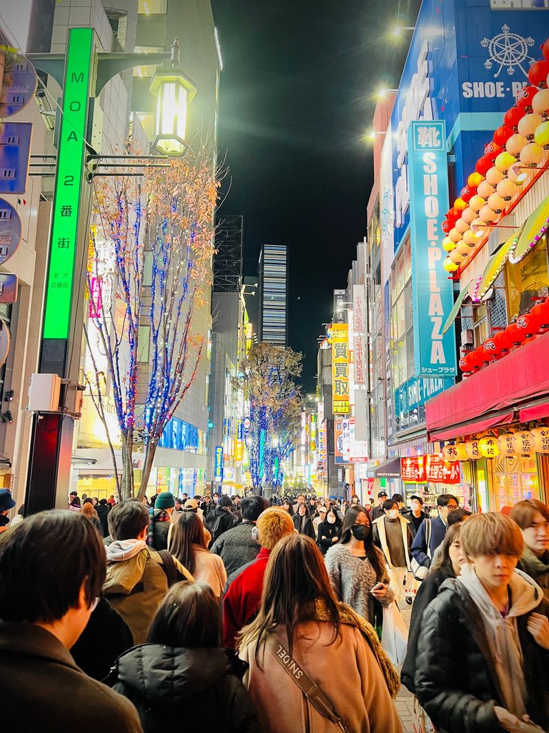A bustling Shinjuku street filled with neon signs at night